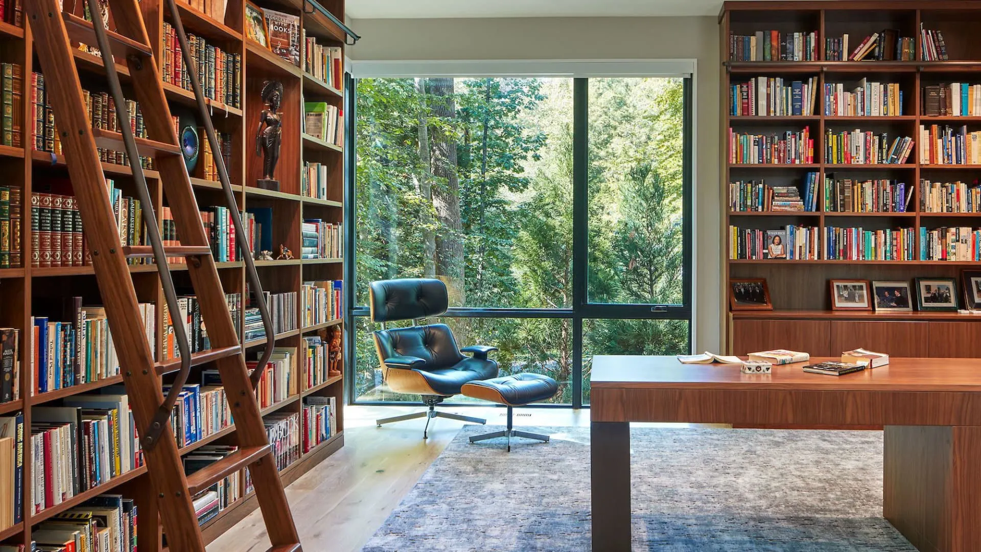 Luxury home library design with floor-to-ceiling bookshelves, a comfortable reading chair, and a marble side table creating an elegant reading corner layout.