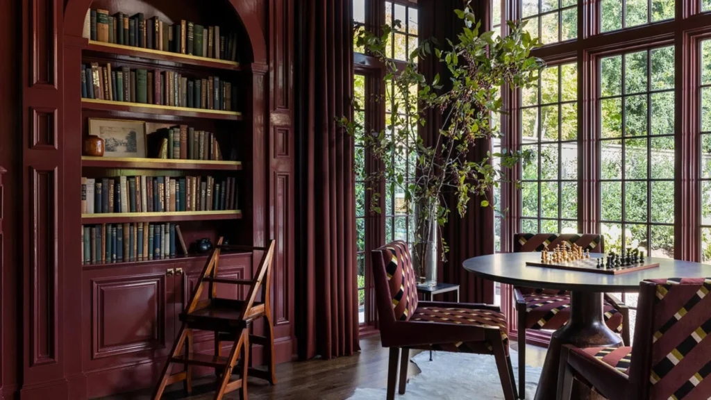 Luxury home library design with floor-to-ceiling bookshelves, a comfortable reading chair, and a marble side table creating an elegant reading corner layout.