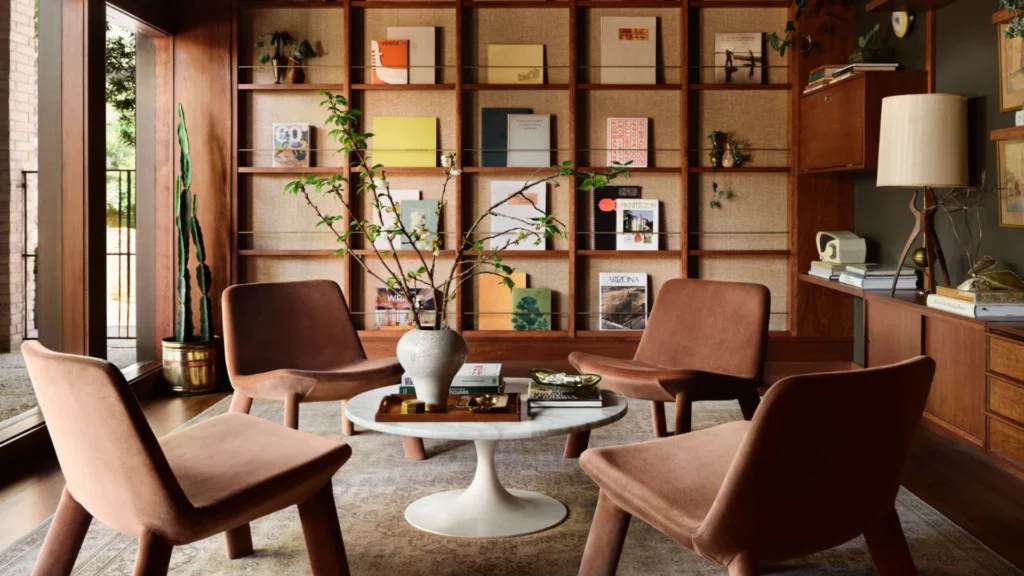 Luxury home library design with floor-to-ceiling bookshelves, a comfortable reading chair, and a marble side table creating an elegant reading corner layout.
