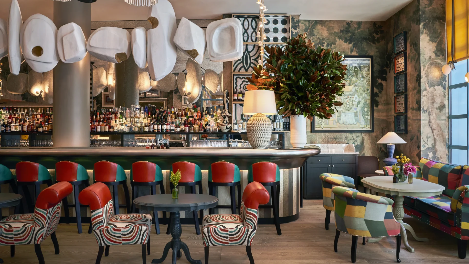 Pattern-rich and layered interior spaces inspired by Kit Kemp’s British interior design style featuring vibrant textiles, bold colors, and eclectic decorative elements.