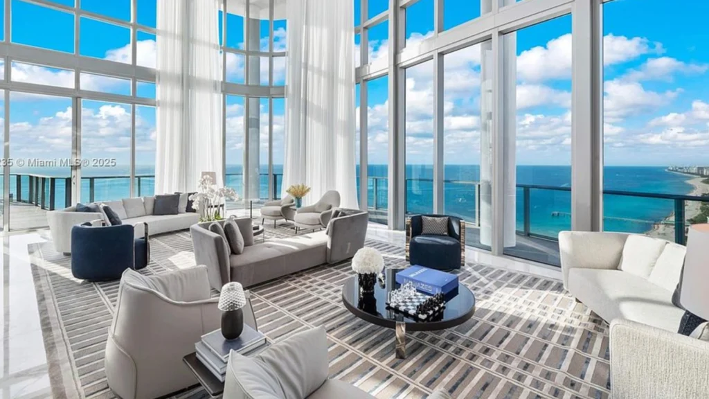 Miami beachfront condo living room with panoramic Atlantic Ocean views and contemporary coastal luxury interior design.