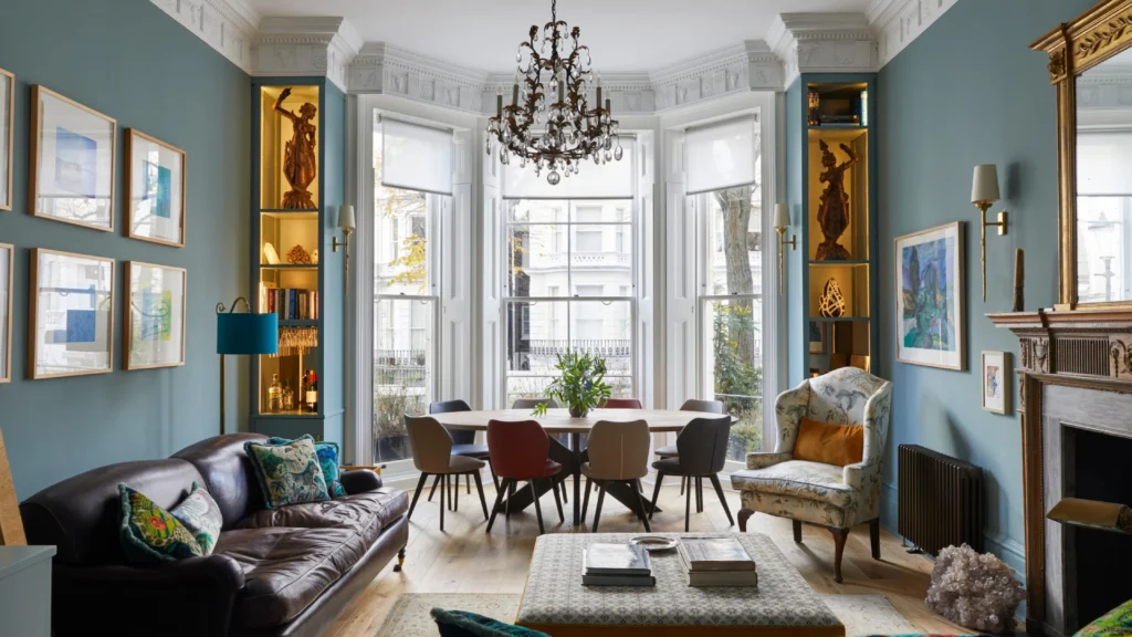 Elegant Notting Hill townhouse living room with a sofa placed between tall French doors, showcasing refined London period home interior design with natural light and garden views.