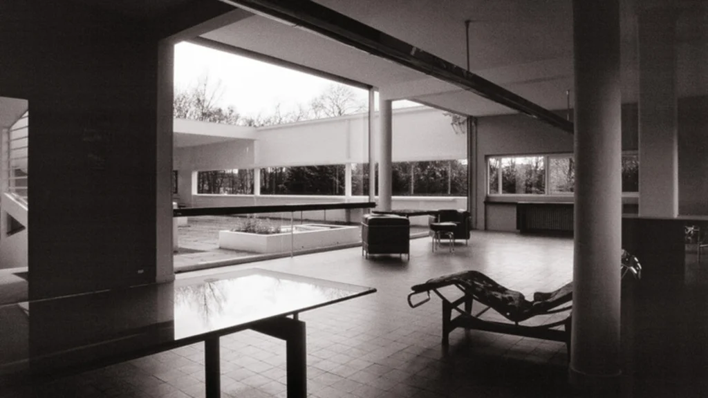 Villa Savoye by Le Corbusier in Poissy, France, iconic example of modernist architecture featuring white facade, ribbon windows, pilotis columns, and minimalist modernist design.
