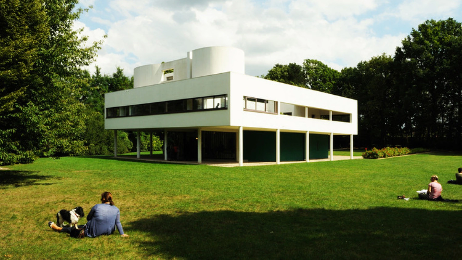 Villa Savoye by Le Corbusier in Poissy, France, iconic example of modernist architecture featuring white facade, ribbon windows, pilotis columns, and minimalist modernist design.