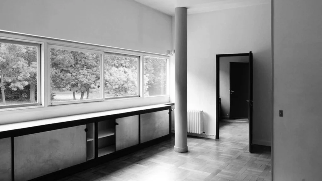 Villa Savoye by Le Corbusier in Poissy, France, iconic example of modernist architecture featuring white facade, ribbon windows, pilotis columns, and minimalist modernist design.