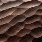 Campione di noce finemente intagliato, che mostra opzioni di finitura testurizzata nel processo di design di mobili di lusso su misura di Nolita Harbour.