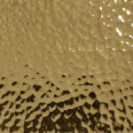 Textured hammered brass sample with honeycomb pattern, showcasing bespoke finish options in luxury furniture design by Nolita Harbour.
