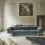 Elegant room at Palazzo Digerini by Vincenzo de Cotiis with a blue velvet sofa, rustic beige walls adorned with intricate molding, a large classical painting, and minimalistic wooden furniture.