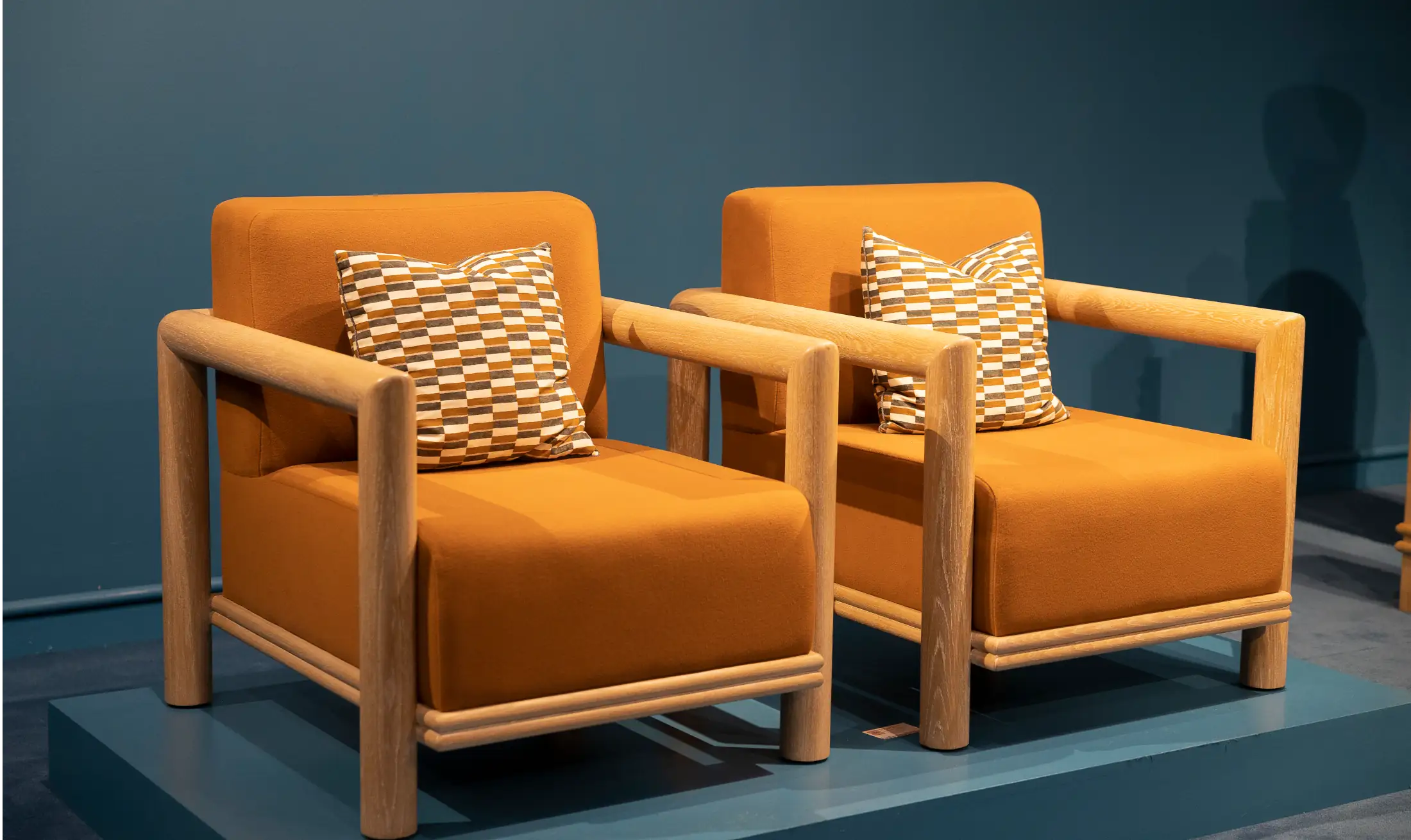 Pair of luxury armchairs with sculptural timber frames displayed at High Point Market